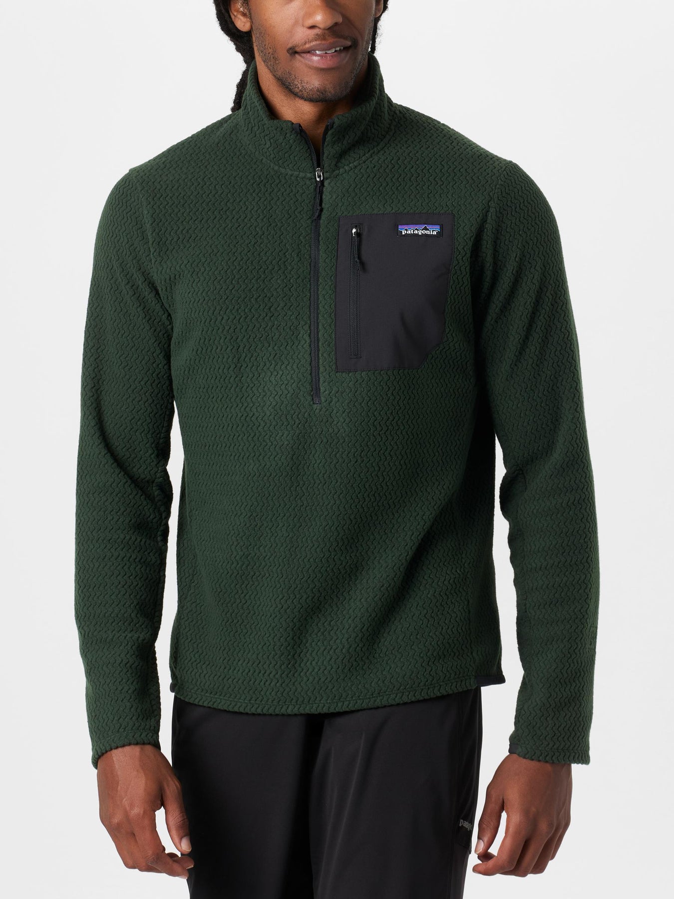 Male model wearing the Patagonia R1 Air Zip Neck in a dark green colorway