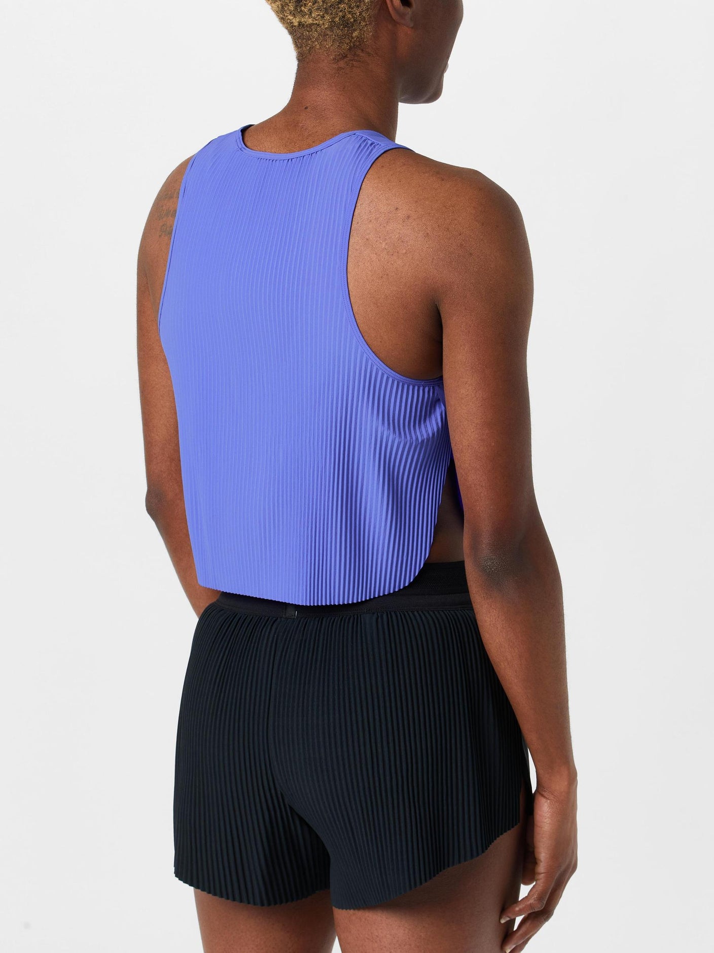 Back view of model wearing Nike Dri-FIT ADV Aeroswift Crop Tank in purple colorway