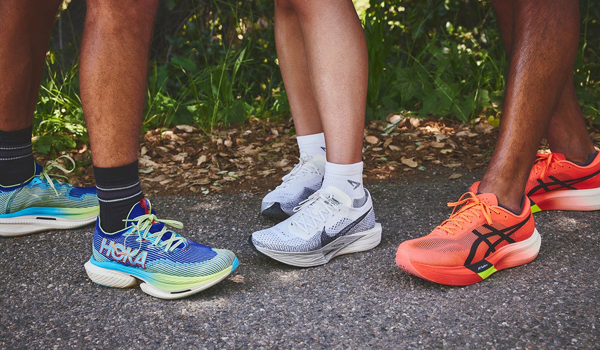 Close up shot of a group of runners' legs with carbon plated shoes on their feet