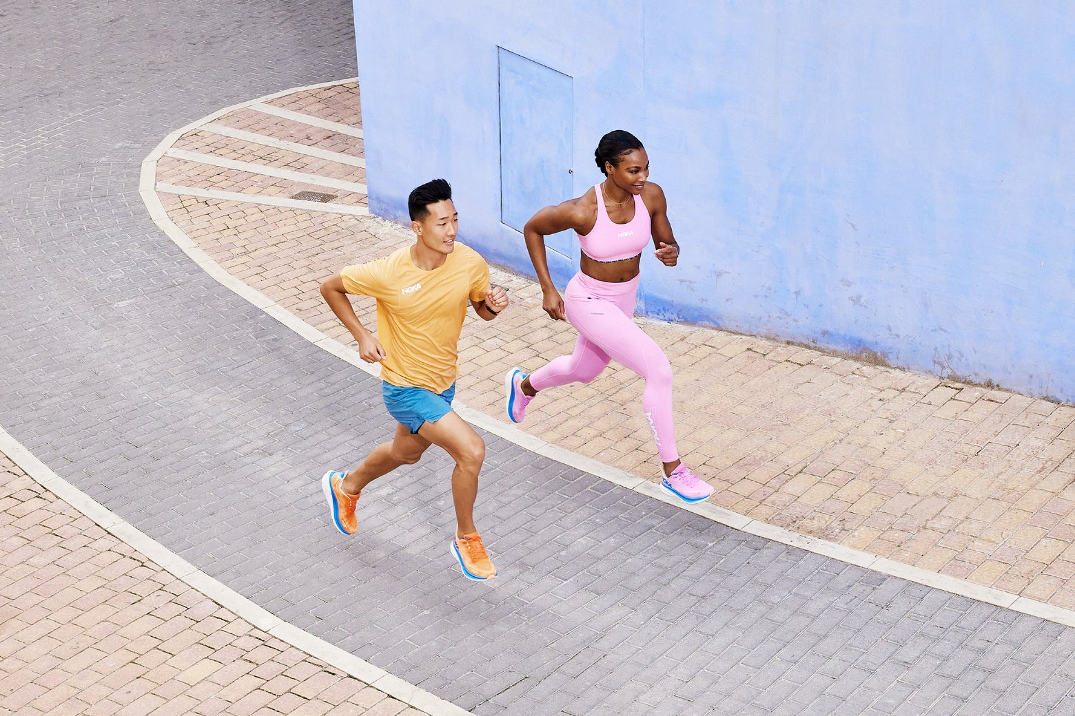 Man and woman running in HOKA Cliftons