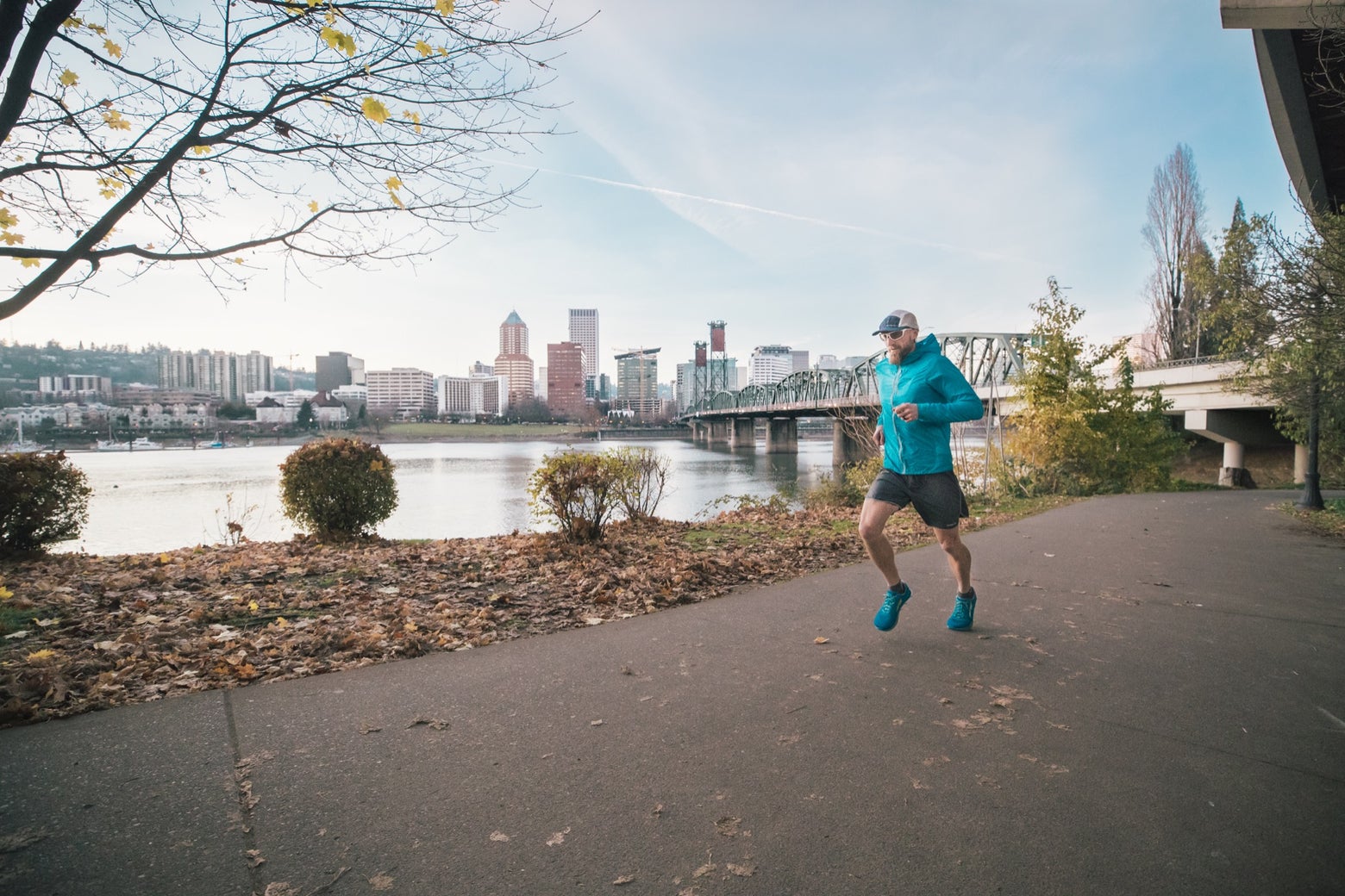 Person running along a river on a concrete path in the city