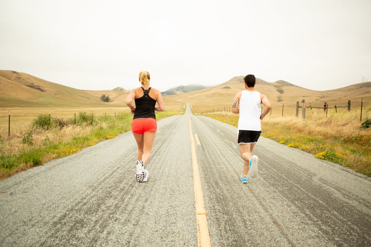 Man and woman running on an empty open road