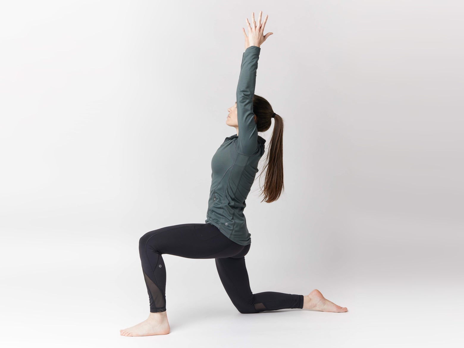 Woman on bended knee with her arms raised vertically