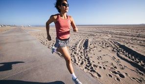 Female runner wearing Fuel n Fly shorts running by the beach