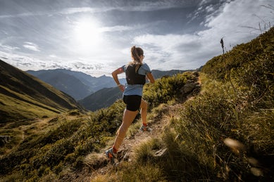 Female runner running through hills