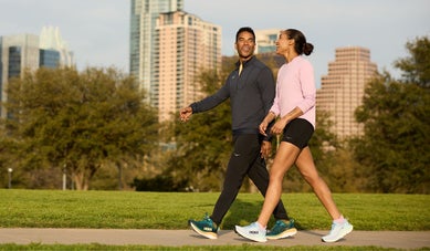 Man and woman smiling and walking in an urban environment