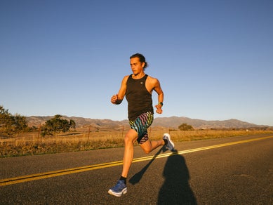 Man running on the road wearing rabbit tank and shorts