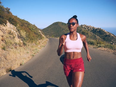 Woman running in a Brooks sports bra and shorts