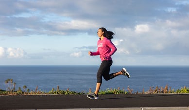 Woman running on the road overlooking the beach