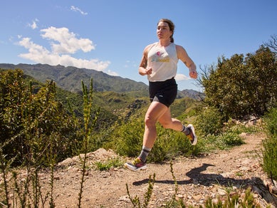 Woman running on the trail wearing Brooks Distance Tank and Brooks shorts