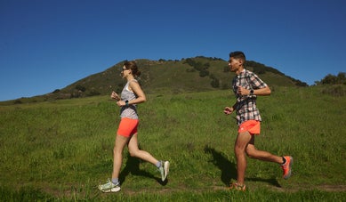 Male and female runners trail running