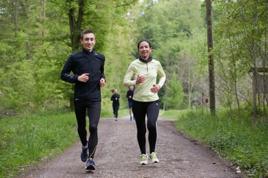 Man and women running on path in the woods