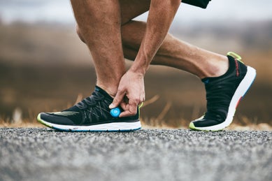 Man adjusting fit of black New Balance running shoe