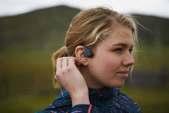 woman tucking hair behind headphones