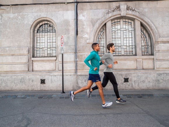 Two men running past windows in long sleeve shirts