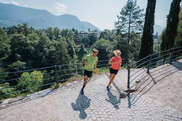 male and female runners running on the road