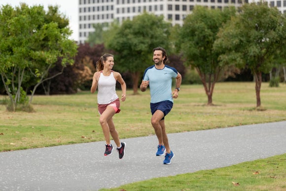 man and woman running through a park