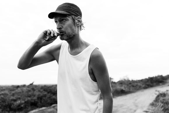 Black and white photo of a man chewing on a Maurten energy gel