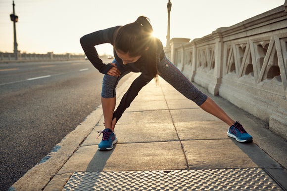 women stretching on sidewalk during sunrise