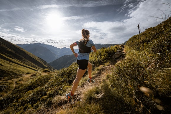 Woman running in the mountains in a Salomon Hydration Vest