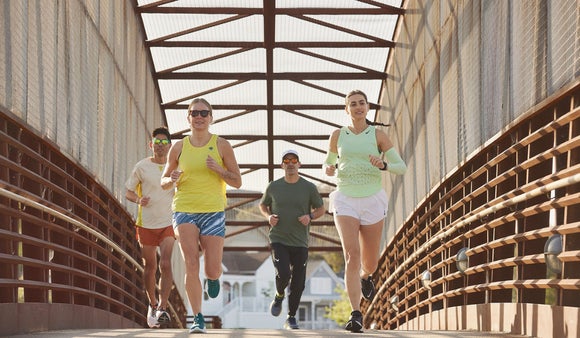 Group of runners wearing sun protective clothing, sunglasses and arm sleeves
