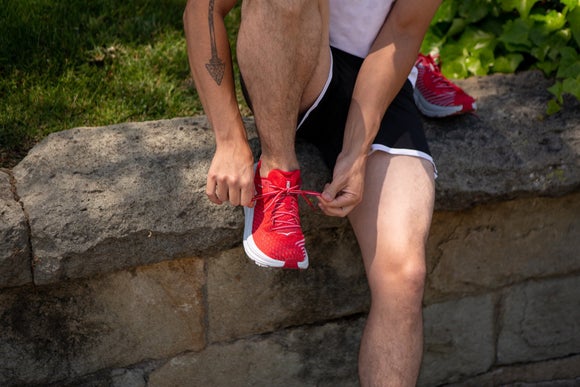 A runner putting on his HOKA Rincon running shoes