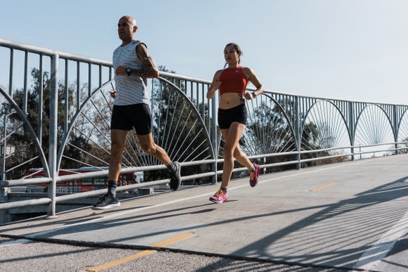 Man and woman running on a bridge