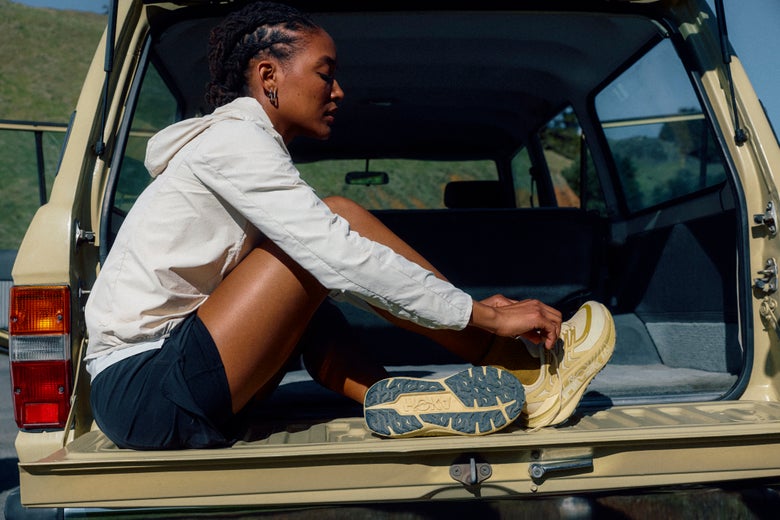 Trail runner sitting in car with HOKA Stinson running shoes