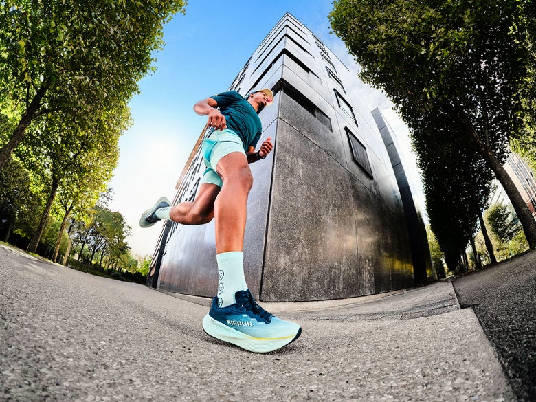 Athlete running through a cityscape wearing the Kiprun Kipride Max
