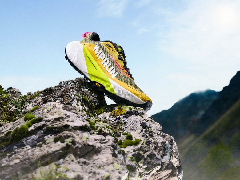 Kipsummit Max in a yellow/green/black colorway perched on mountainous terrain