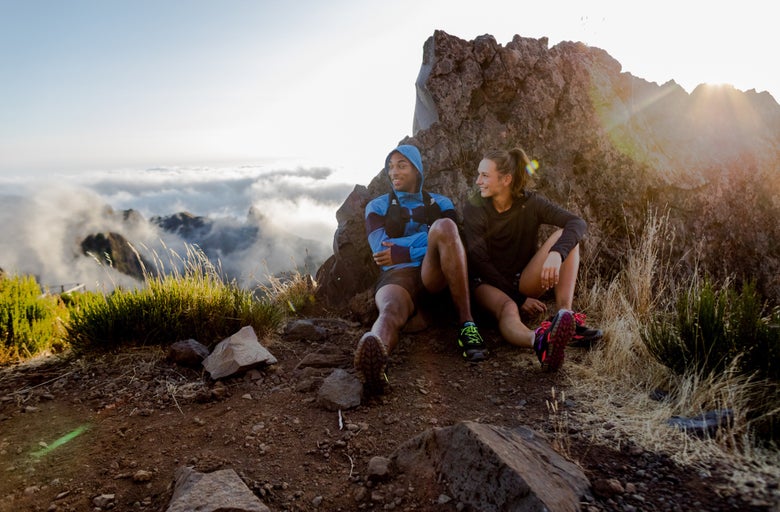 man_and_women_sitting_on_hill_resting