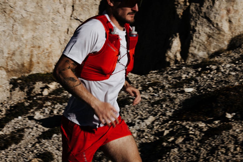 Runner wearing Salomon running vest in front of a rocky background