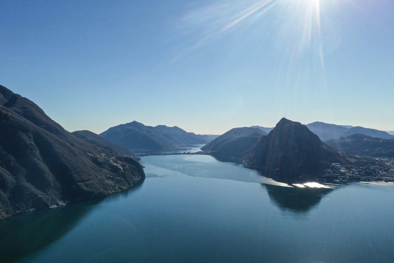 sun shining over the mountains and blue ocean
