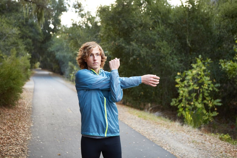 man stretching his arm before a run