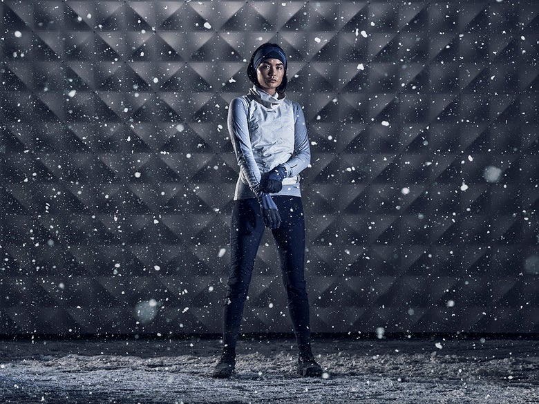 Winter Gear Guide, runner in vest and snow pulling on gloves