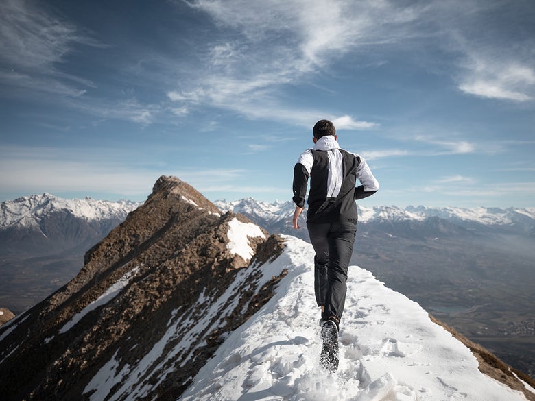 Man running on snowy mountaintop