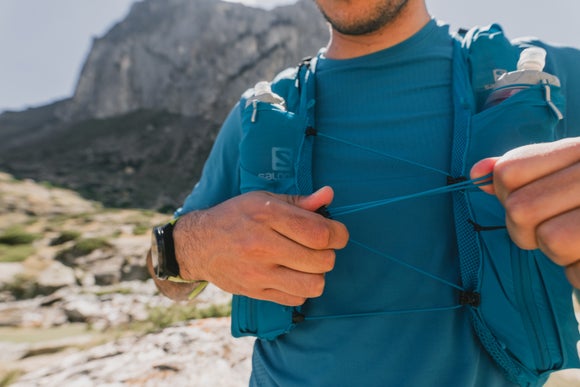 Salomon Sense Pro Set Pack in ocean blue on a trail runner in the mountains