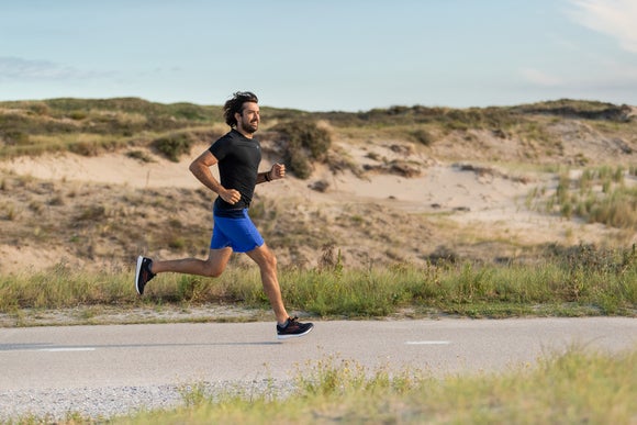 man running on a path while wearing Brooks shoes and a blue shirt