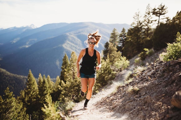 Female trail runner wearing sunglasses.