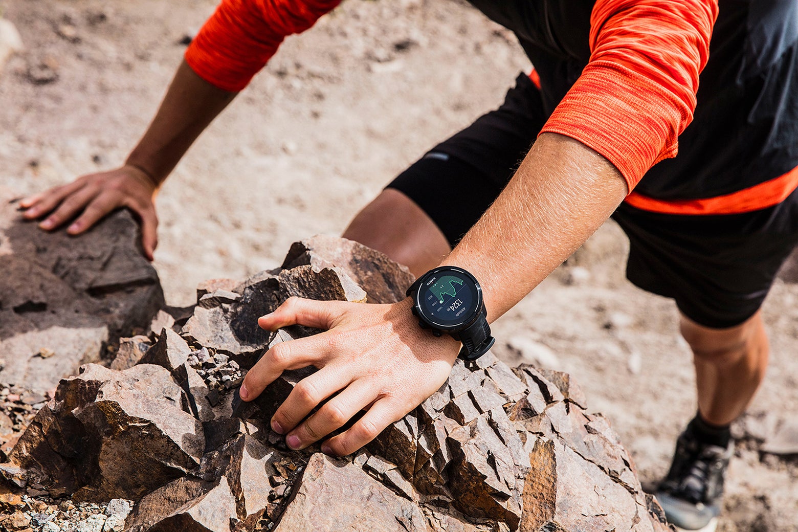 trail runner climbing a steep mountain wearing a gps watch