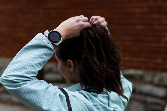 Woman Tying Hair Wearing a Garmin Watch