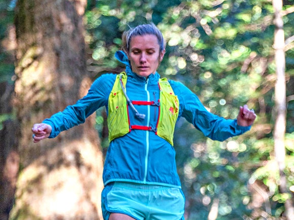 Female runner in nature wearing the Nathan Pinnacle hydration vest