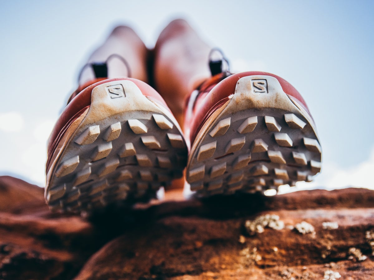 Close up shot of the outsole pronounced lugs of Salomon trail shoes on foot