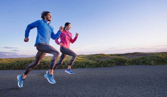 Male and female runners wearing asics shoes while running