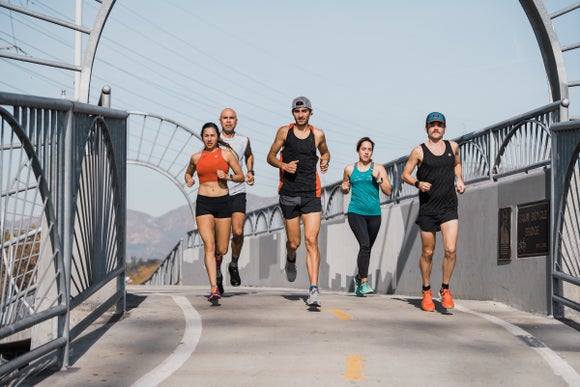 group of runners running on the bridge 