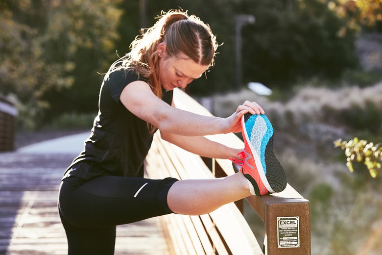 runner stretching on a bridge